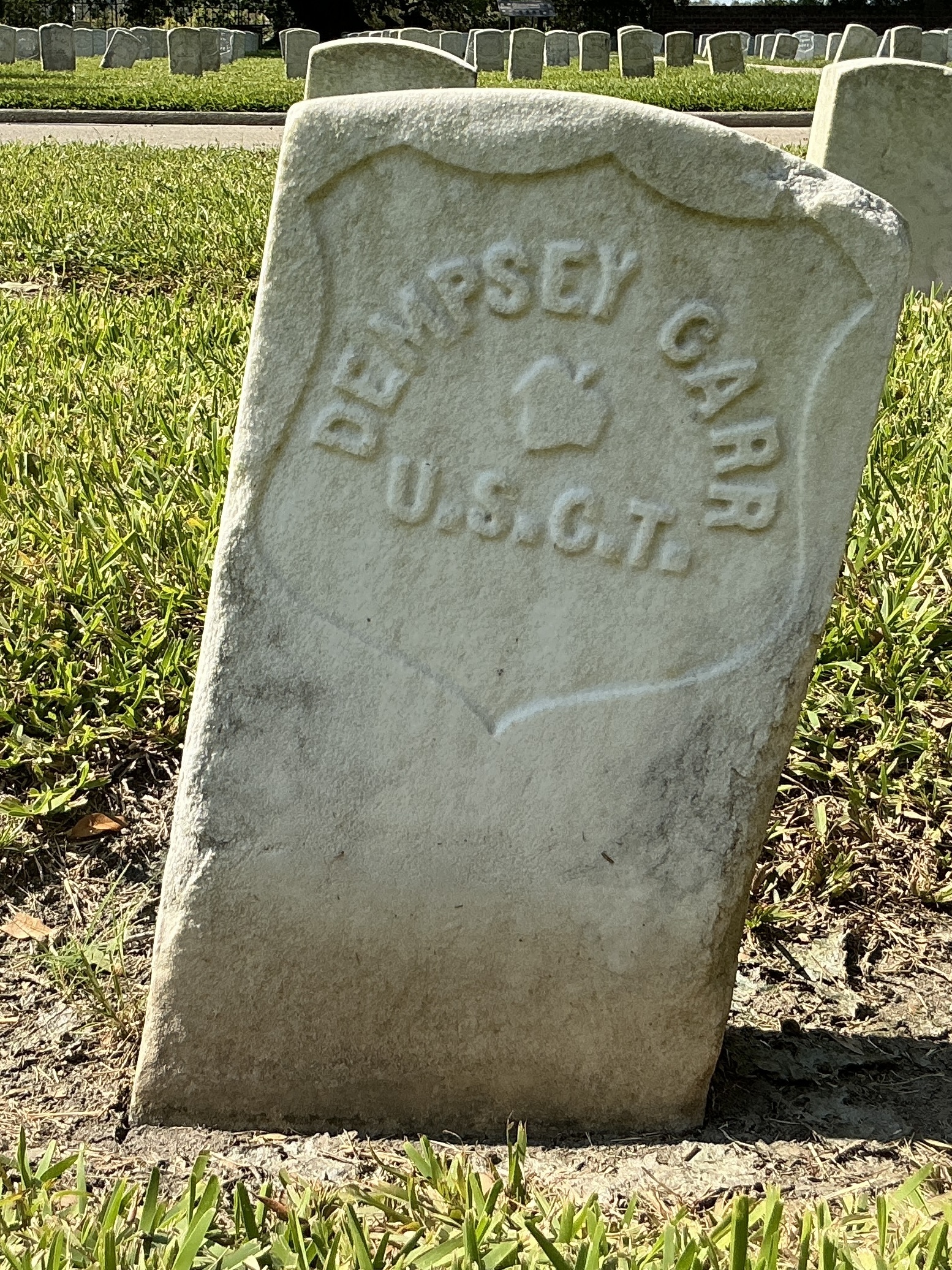 Back of historic upright marble headstone with recessed shield with recessed lettering face.