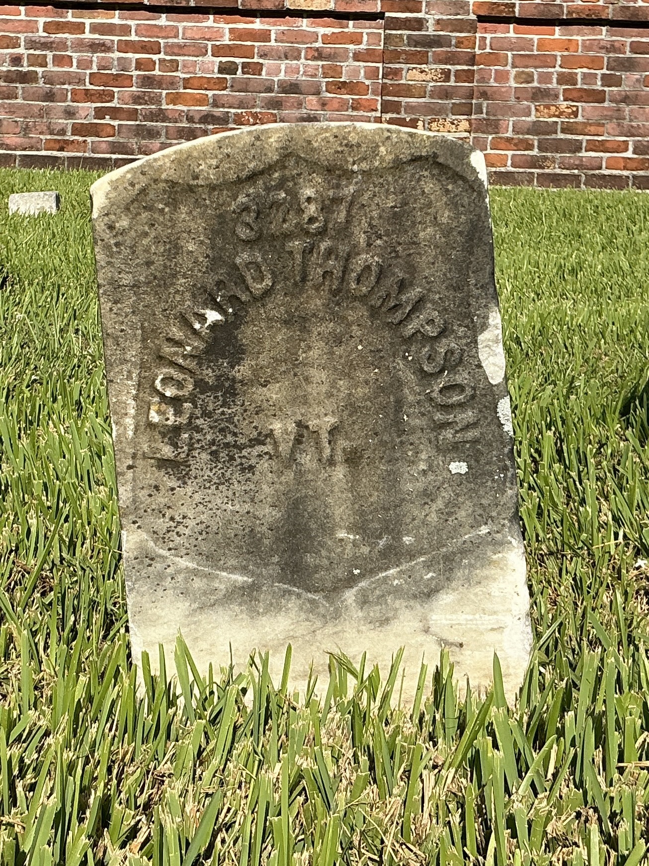 Front of historic upright marble headstone with recessed shield face.