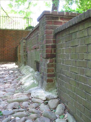 Cobblestone courtyard and adjacent wall of 18th century stable/carriagehouse in the Rose Barden in May 2009.