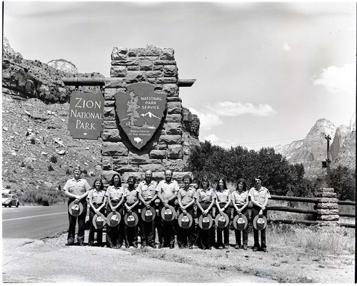 BW Photos of Interpretation Personnel. Staff posing in front of South Entrance sign.