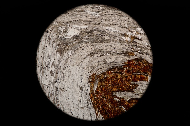 Circular microscopic image of rock structure.
