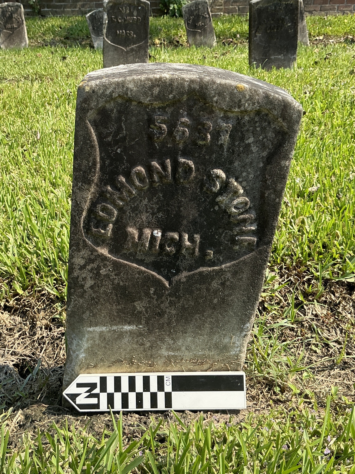 Extra image of historic upright marble headstone with recessed shield face.