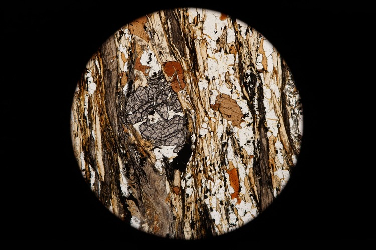 Circular microscopic image of rock structure.
