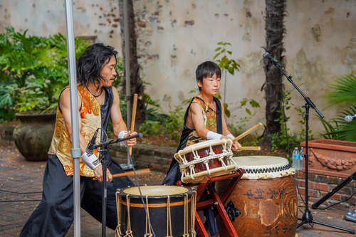 Two percussionist drumming in French Quarter courtyard