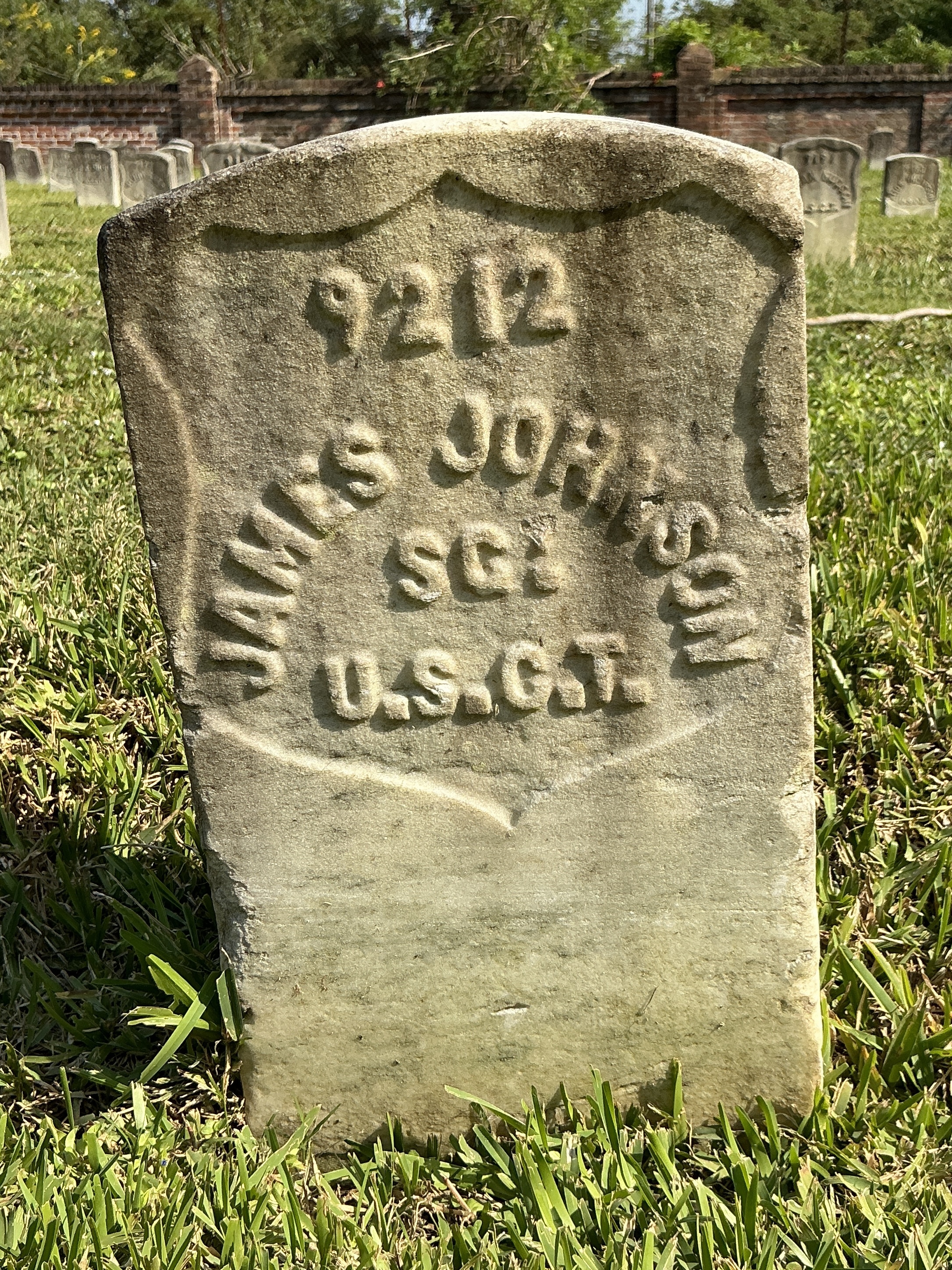 Front of historic upright marble headstone with recessed shield face.