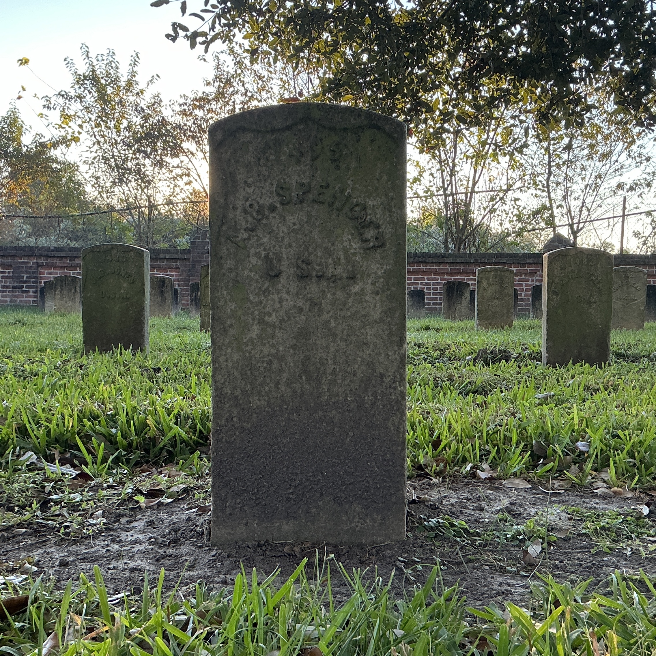 Front of historic upright marble headstone with recessed shield face.