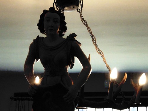 A photograph of a chandelier of a women.