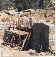 Workman placing ring stone for new headwall