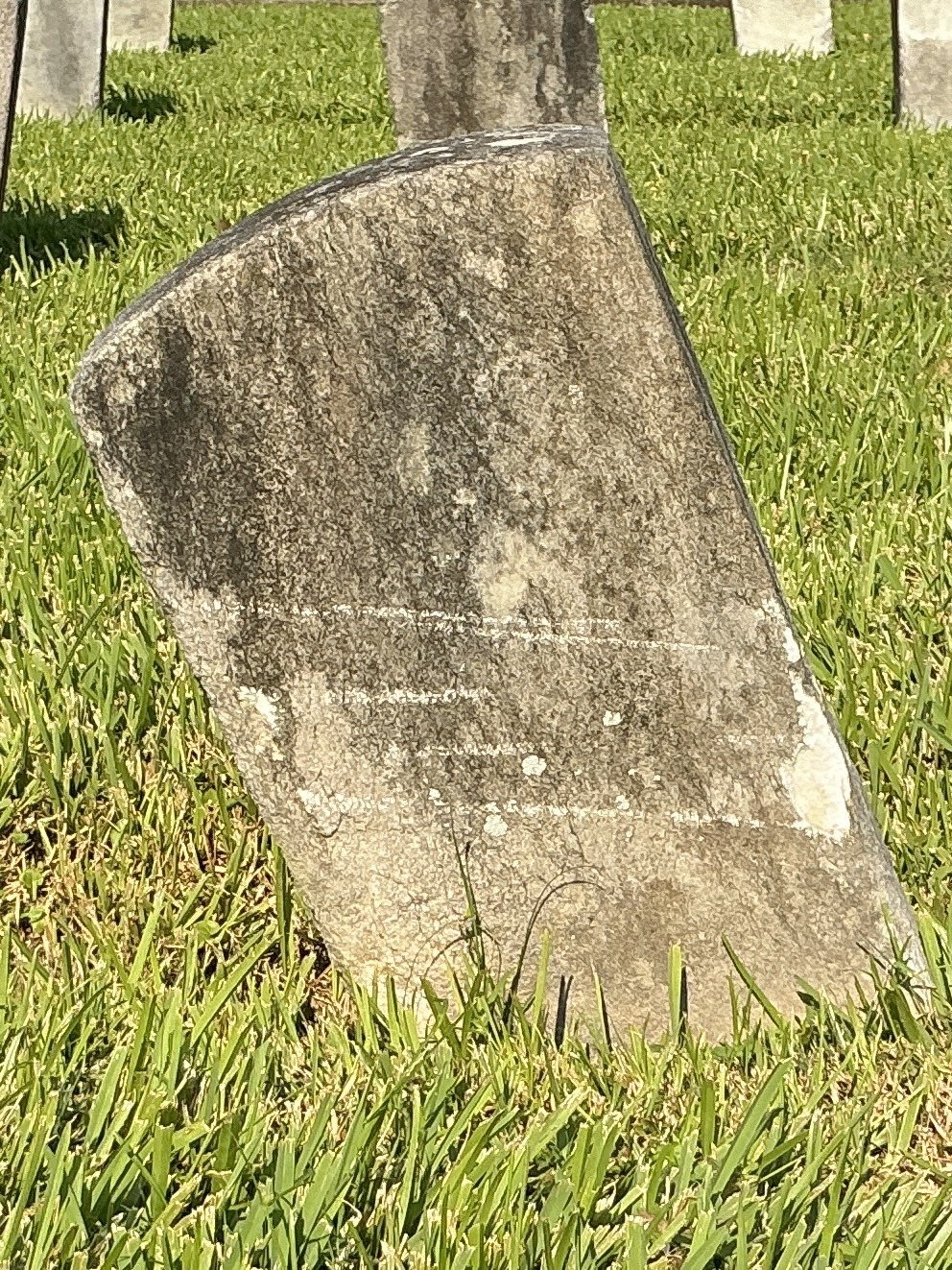 Back of historic upright marble headstone with recessed shield face.