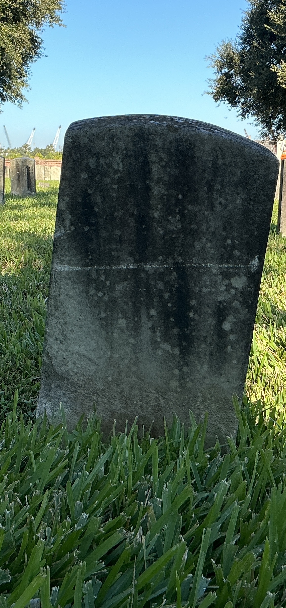 Back of historic upright marble headstone with recessed shield face.