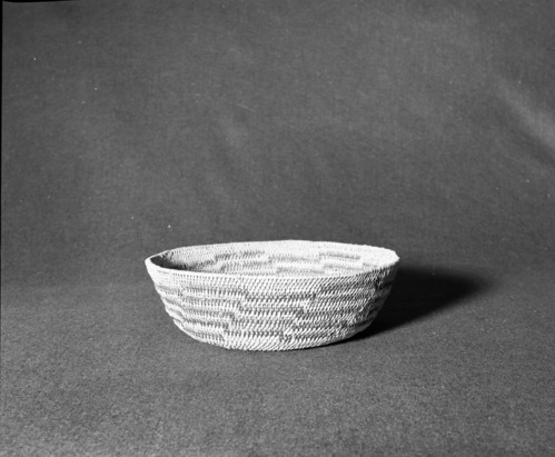 Marie Rozier Collection, Catalog No. 50. Object: Miwok basket. Dimensions: 10 1/2 x 3 1/4". Materials: Split redbud, split bull pine. Technology: Single rod, fag ends trimmed on workface; moving ends trimmed on interior; clockspring start plugged with pith (?). Collection History: Given to Dottie McDow by a Native American friend. Used as a sewing basket. Acquired after 1905. Photographed by Michael Dixon in December 1982. Catalogued by Craig Bates and Barbara Beroza. Yosemite Collections, National Park Service.