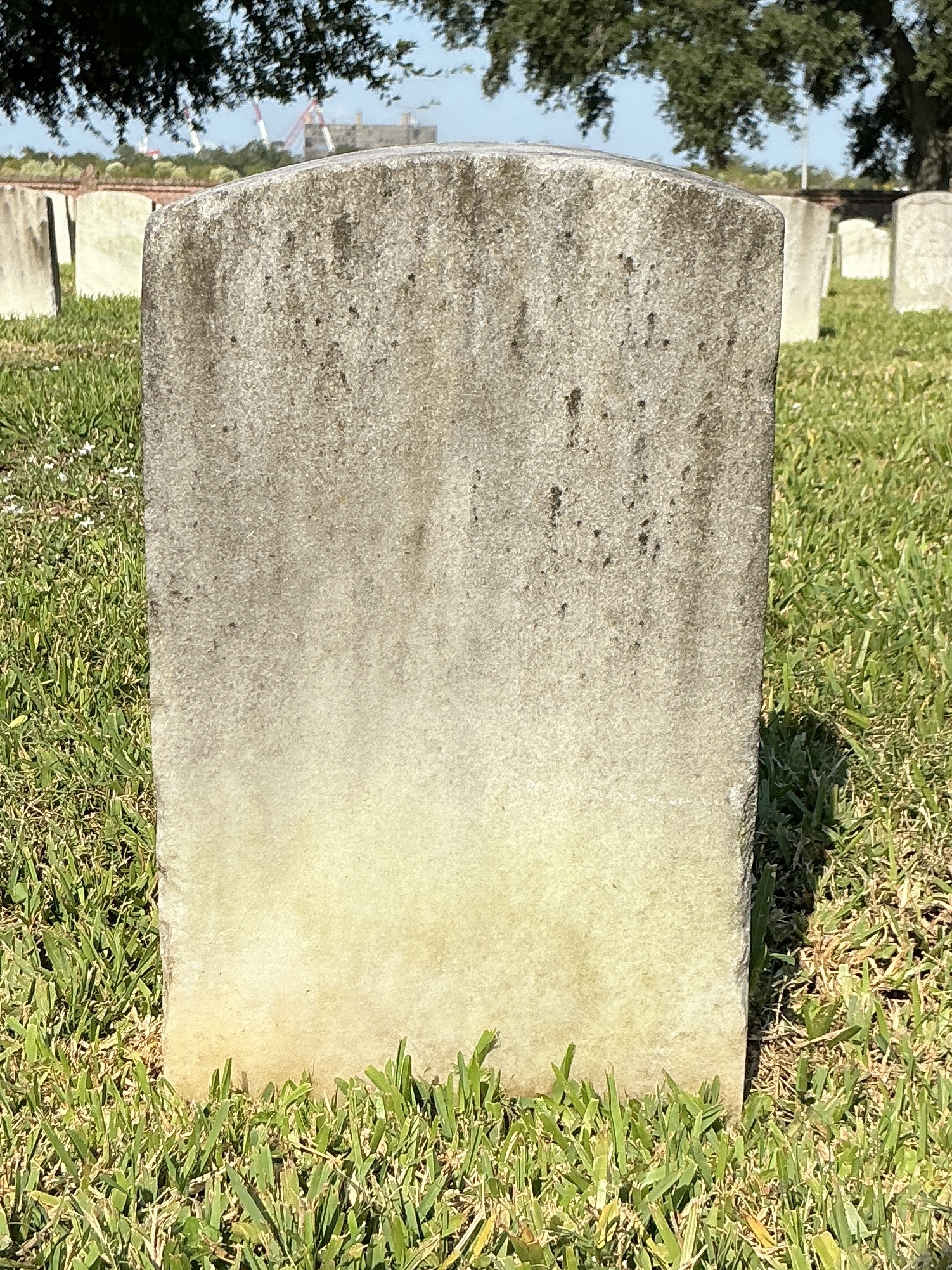 Back of historic upright marble headstone with recessed shield face.