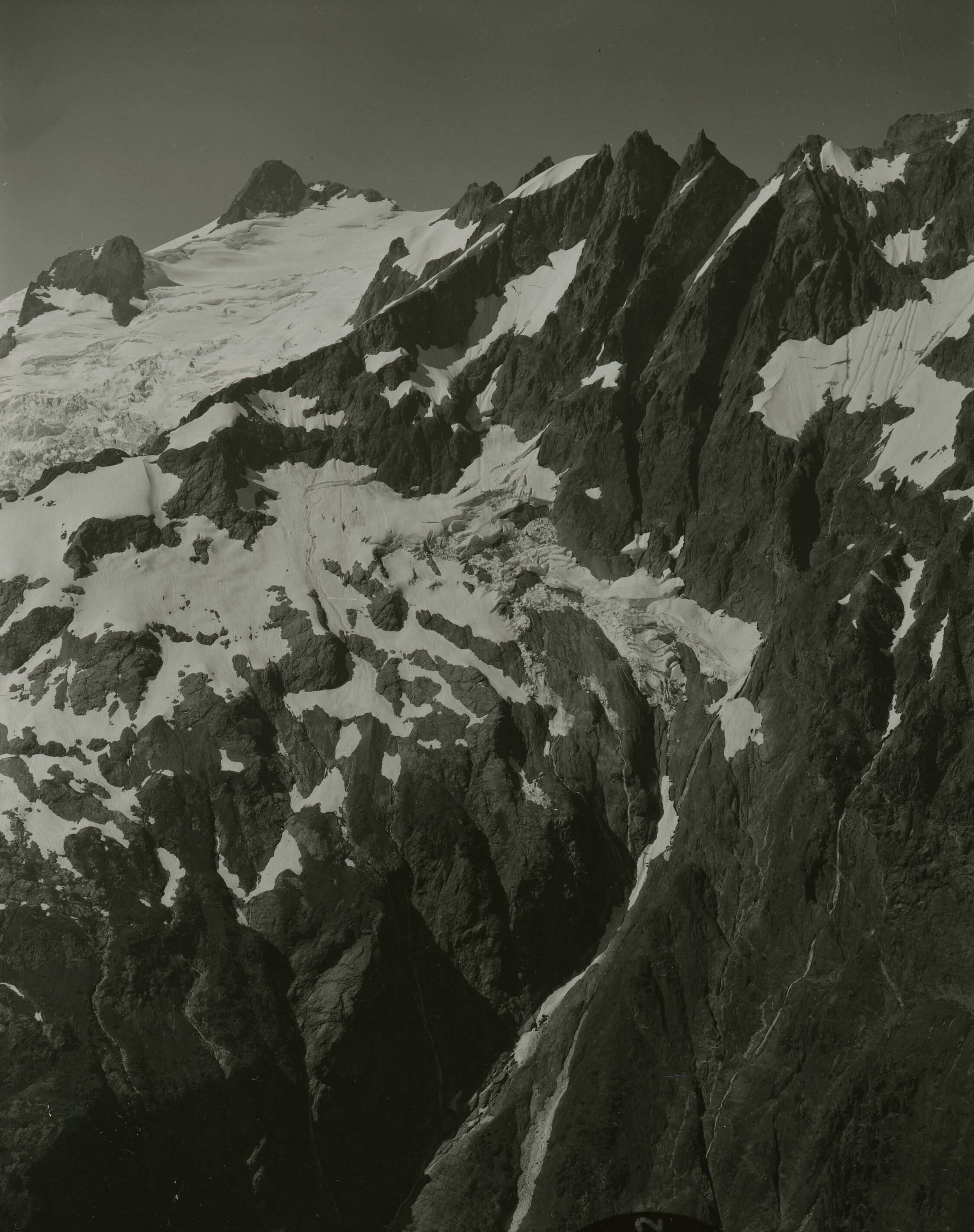 A rugged mountain peak with a glacier in the upper left corner.