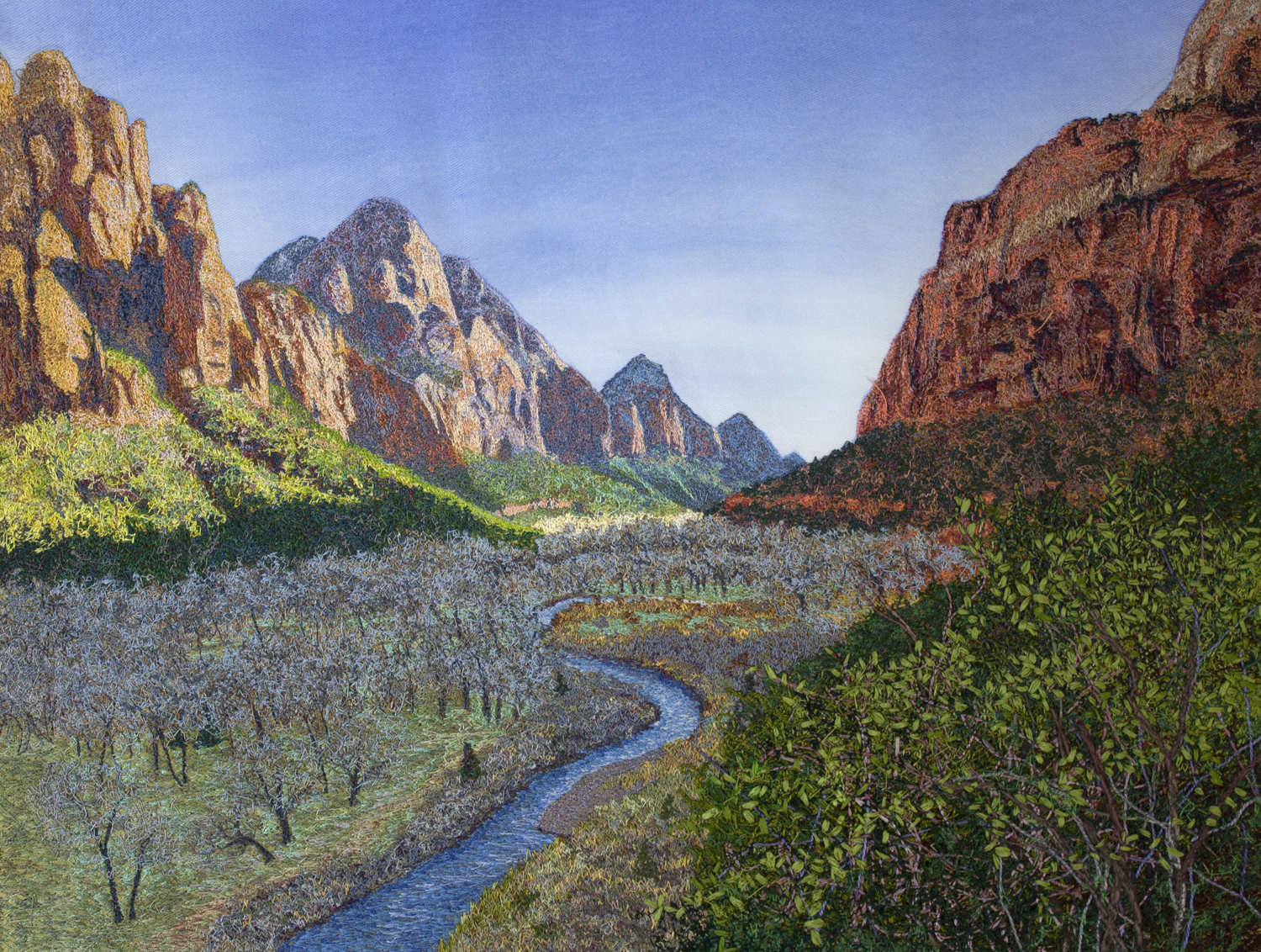 A colorful landscape looking down along a narrow blue river surrounded by trees. Above are orange and red sandstone cliffs against a blue sky.