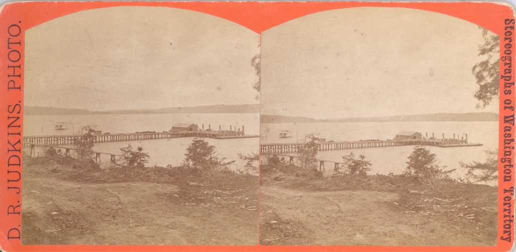 A black and white double stereoscope image with an orange border. Text on one end of the border reads "D.R. Judkins Photo." Text on the other end border reads "Stereographs of Washington Territory."