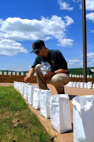 A park volunteer lighting luminaries. 