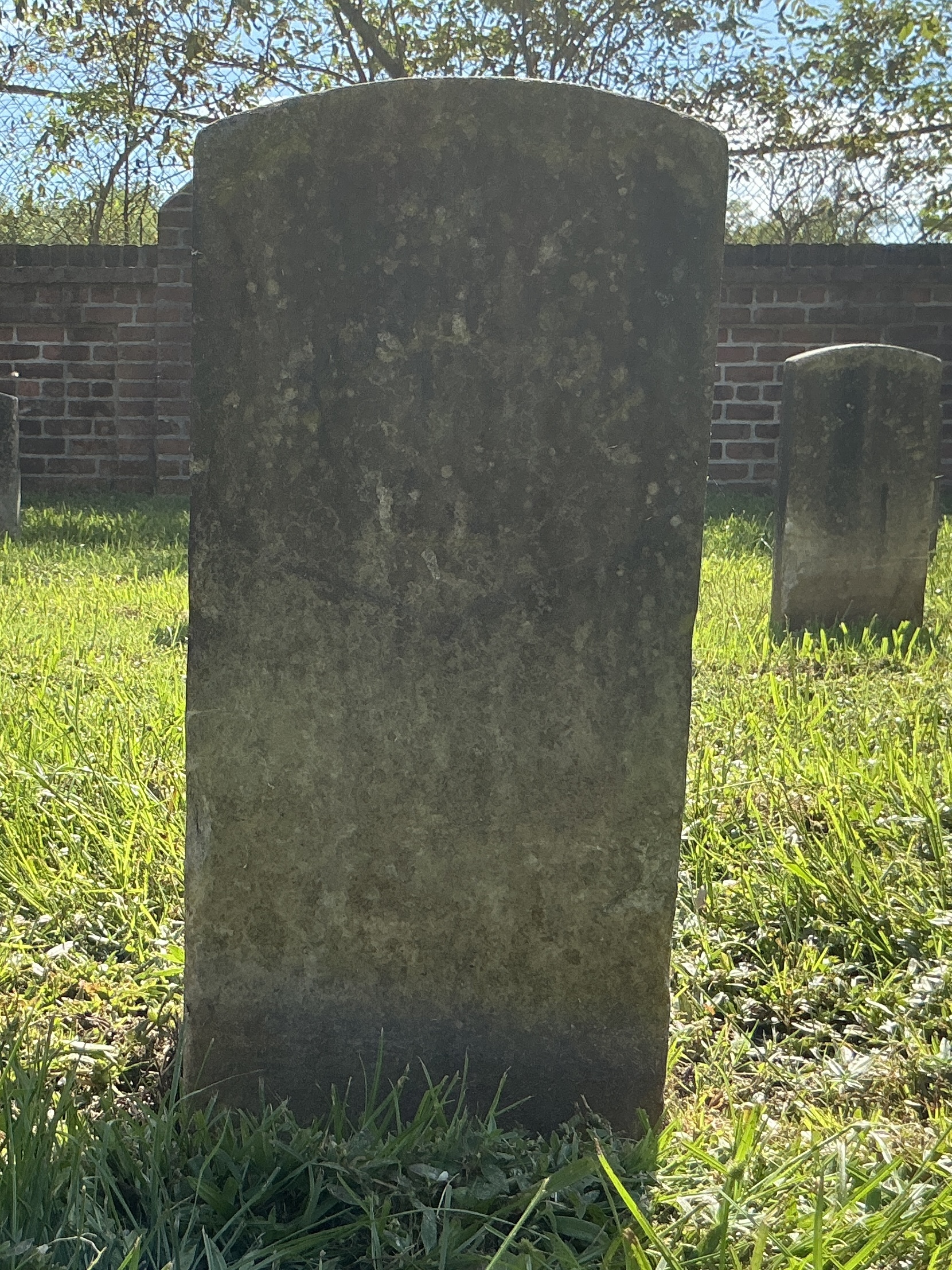 Front of historic upright marble headstone with recessed shield face.