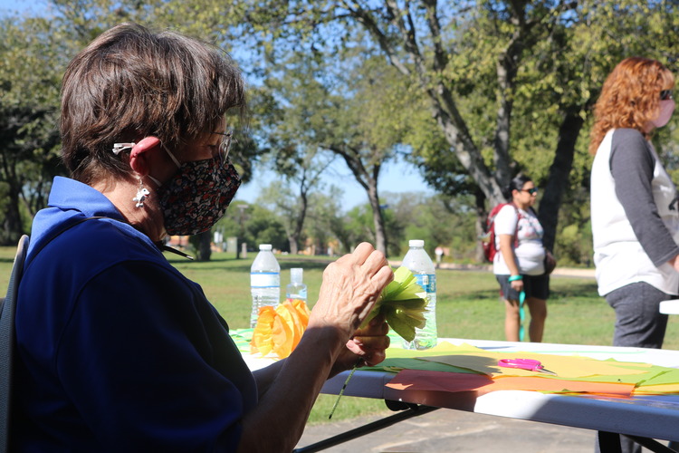 National Park Service Volunteer making a paper flower. 