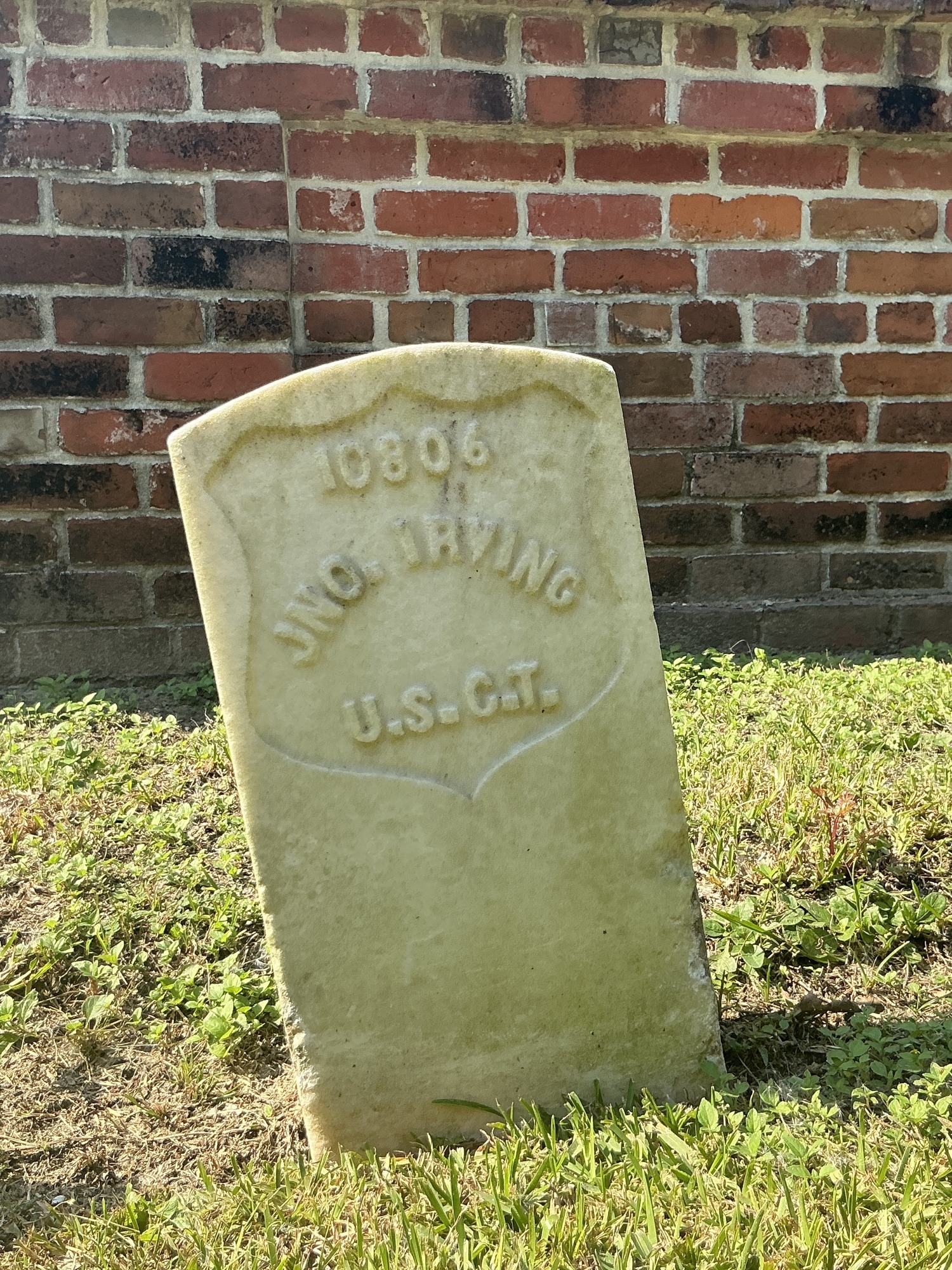 Front of historic upright marble headstone with recessed shield face.
