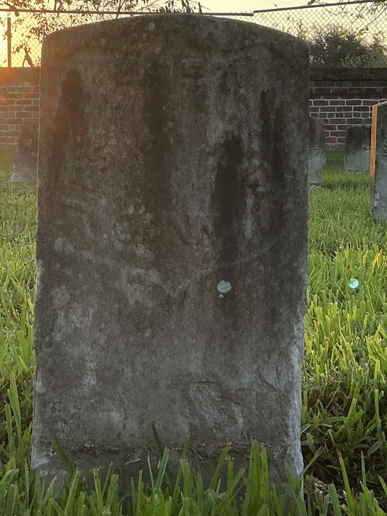 Front of historic upright marble headstone with recessed shield face.