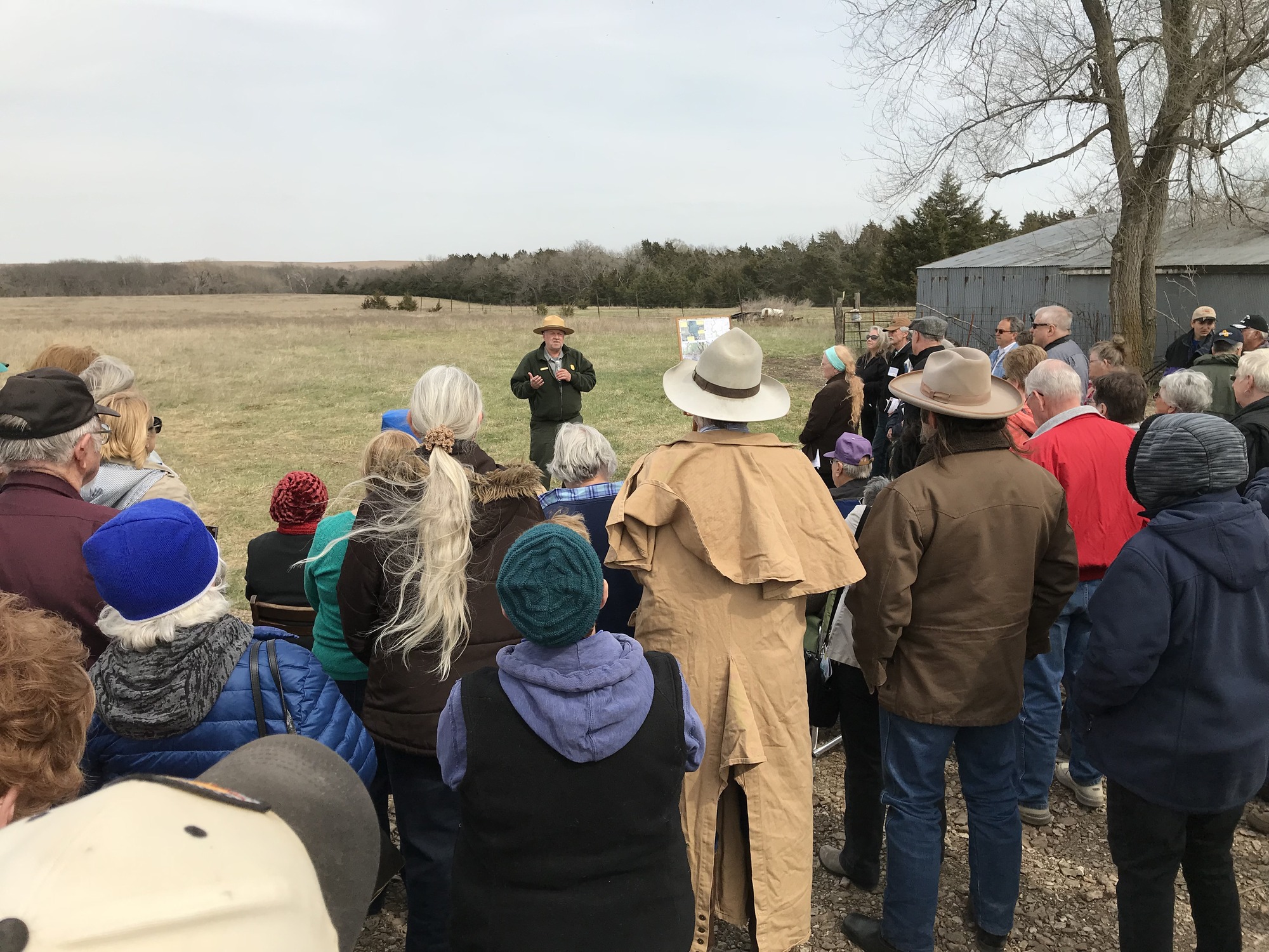 A group of people standing around in a field.