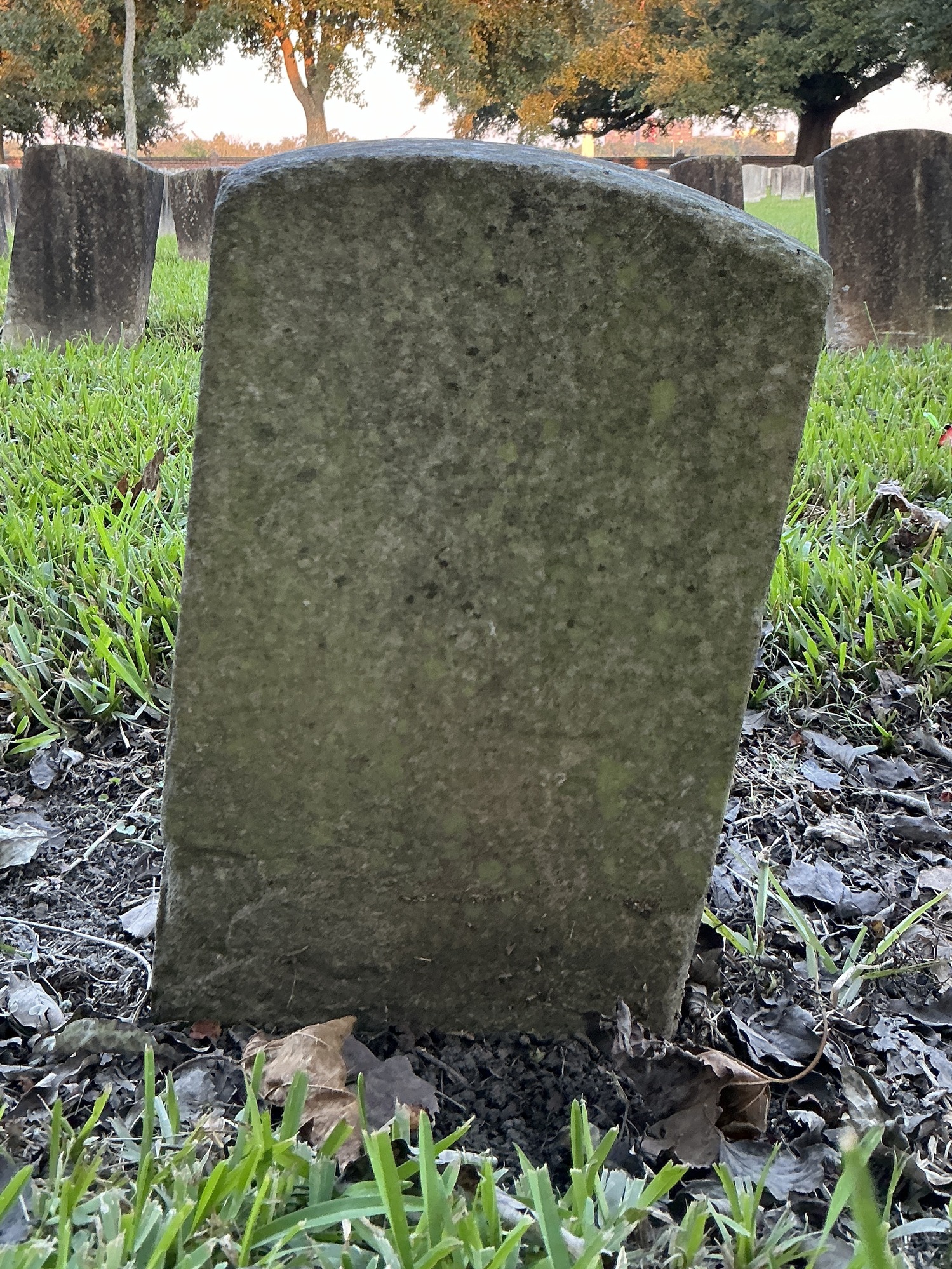 Back of historic upright marble headstone with recessed shield face.
