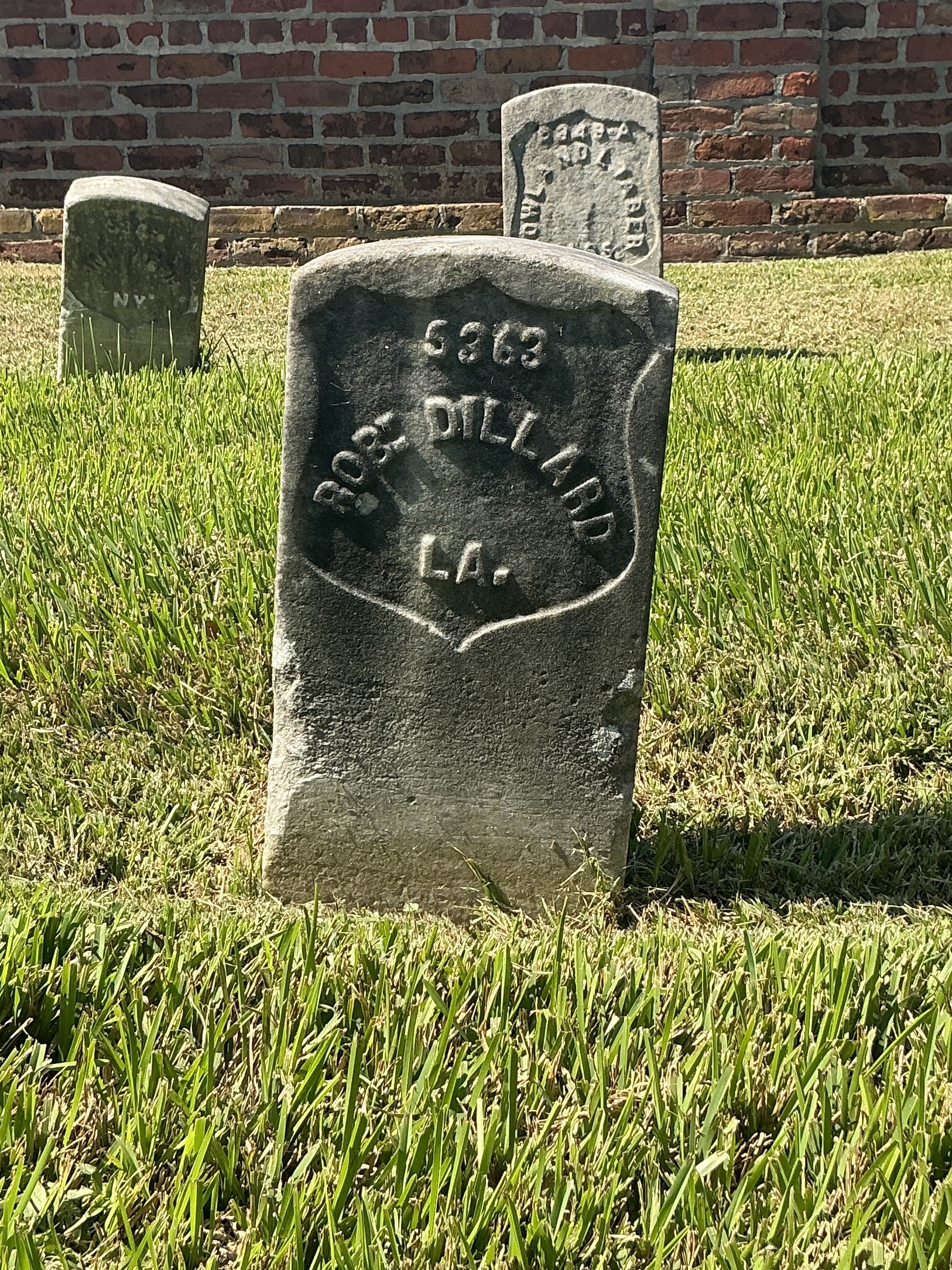Front of historic upright marble headstone with recessed shield face.