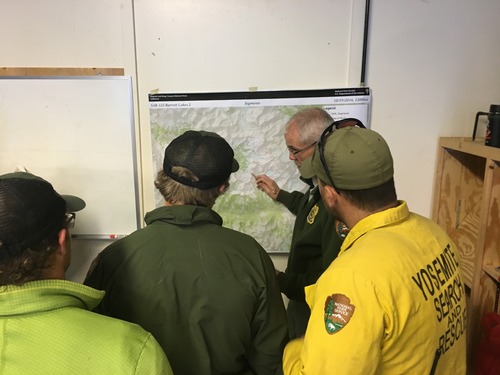 Search and rescue team members consult a topographical map. 