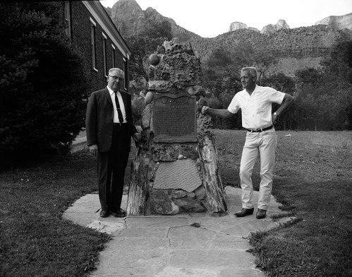 Centennial Preparation Committee members Springdale Mayor Austin Excell and Bishop Alvin Hardy pose next to 'Discovery of Zion Canyon' commemorative plaque.