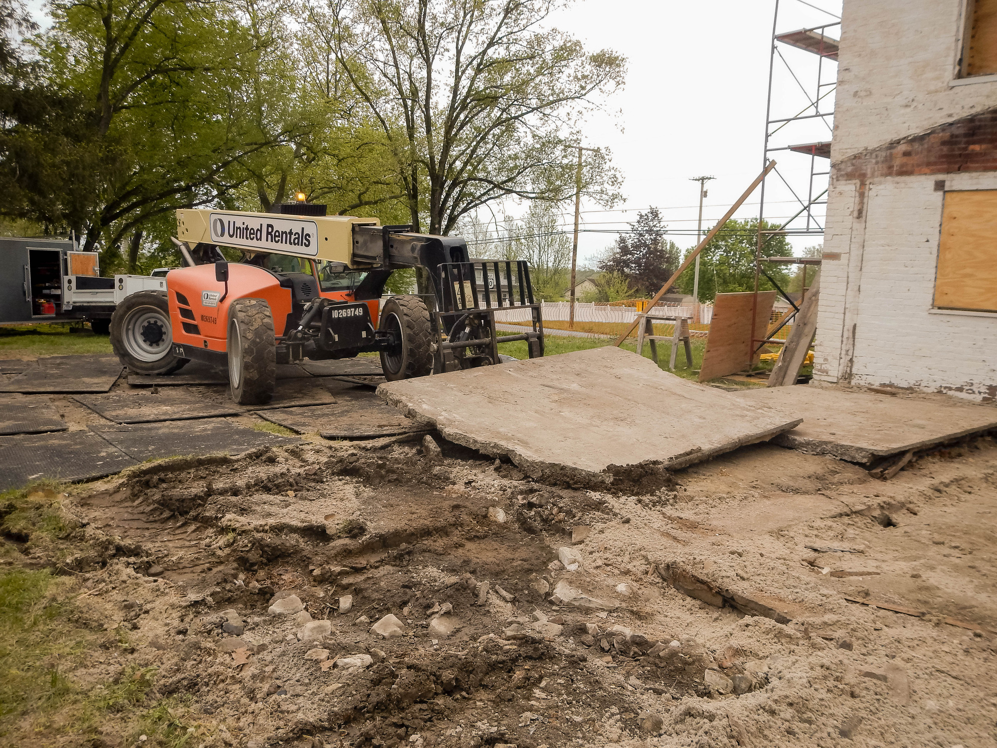 Telehandler is being used to lift sections of cement pad used as a patio for the former addition to the Wisler house. 
