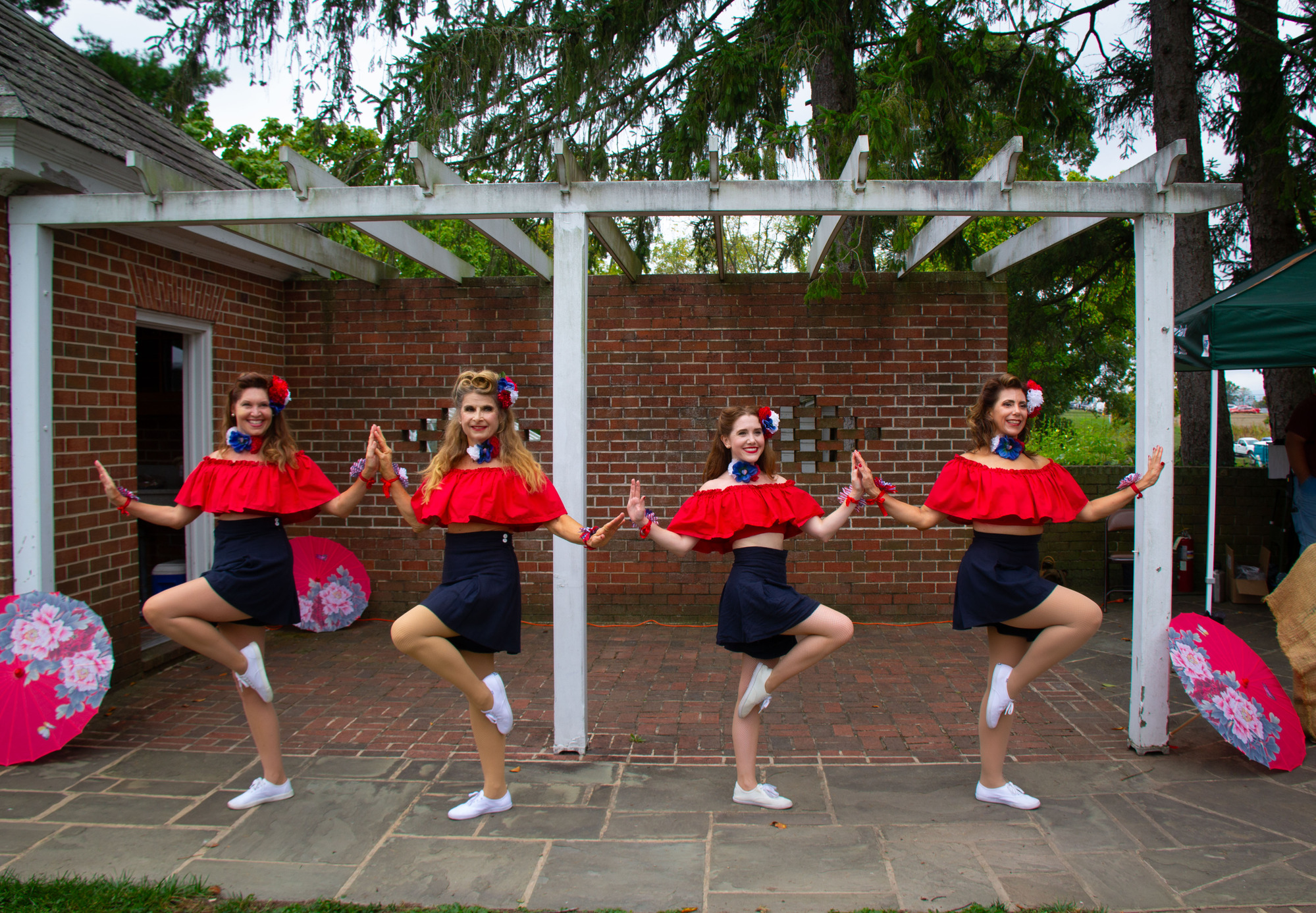 : Four women in dancing costumes pose for photos