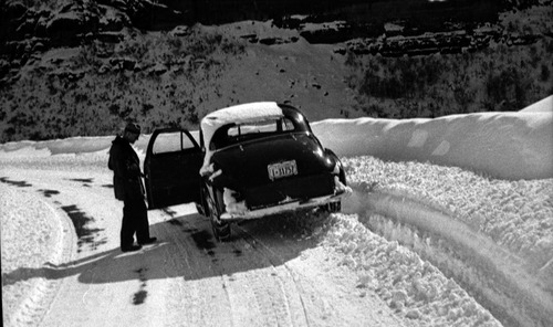 Snowstorm and blocked roads. Chester A. Thomas beside car.