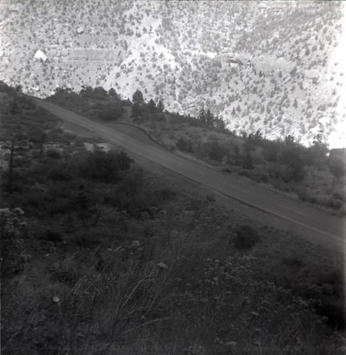 Road and rock retaining wall alongside road at the Zion-Mt. Carmel Highway tunnel.