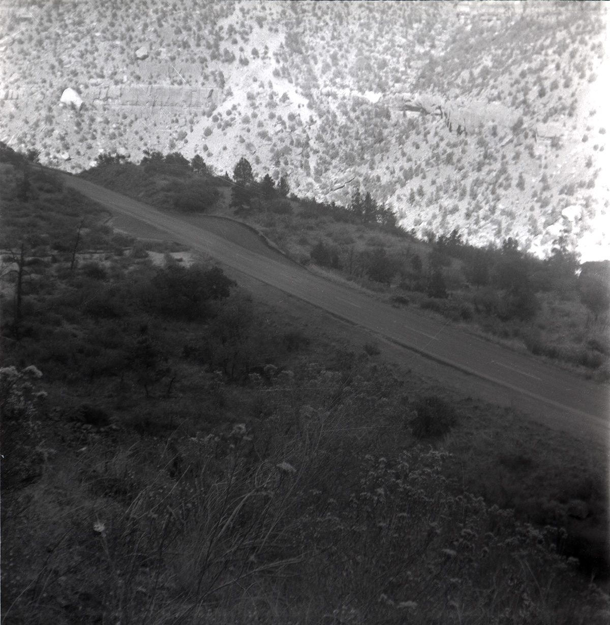Road and rock retaining wall alongside road at the Zion-Mt. Carmel Highway tunnel.