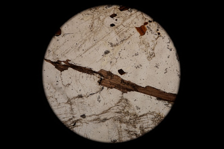 Circular microscopic image of rock structure.