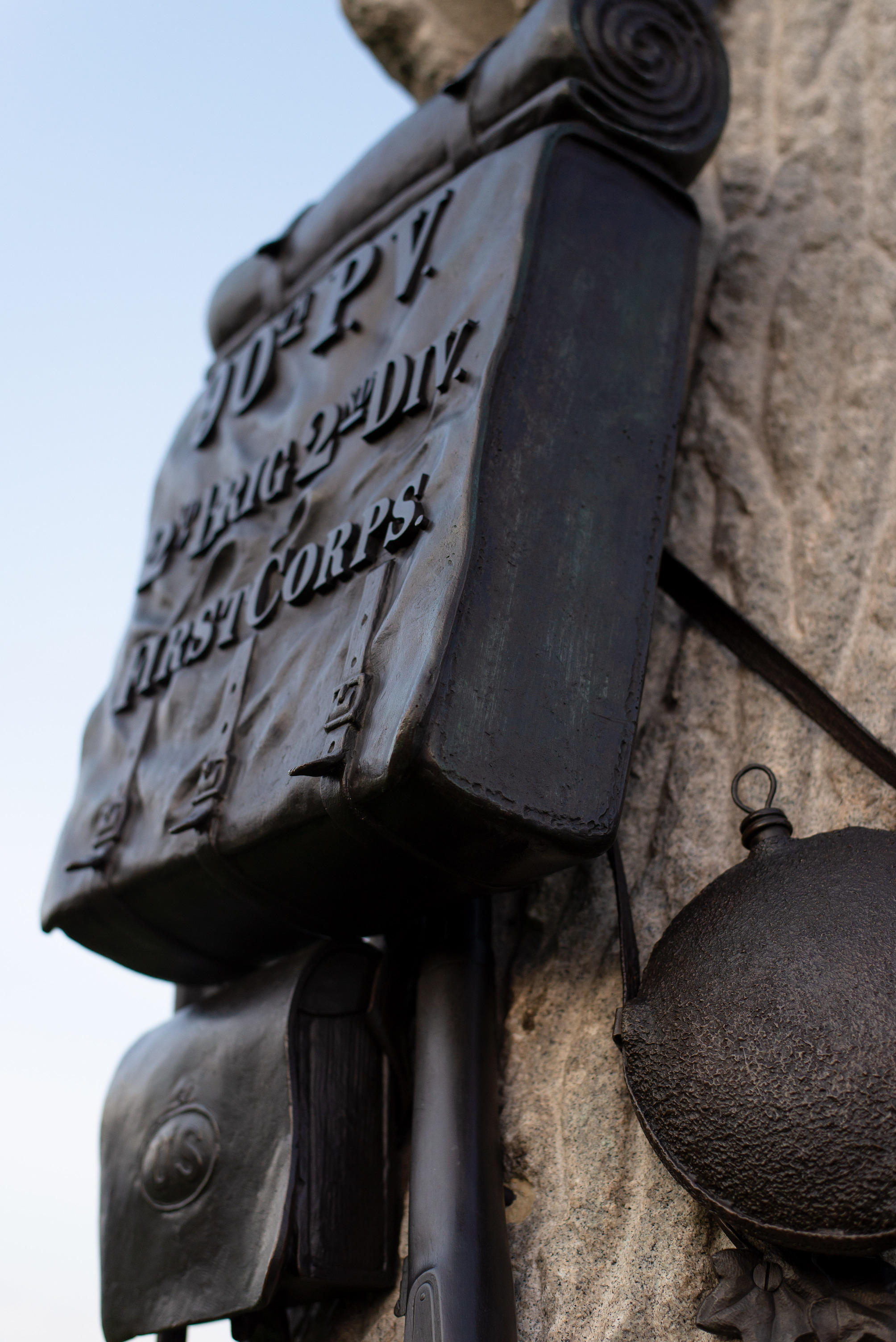 A bronze knapsack with the regiment's name on a stone tree.