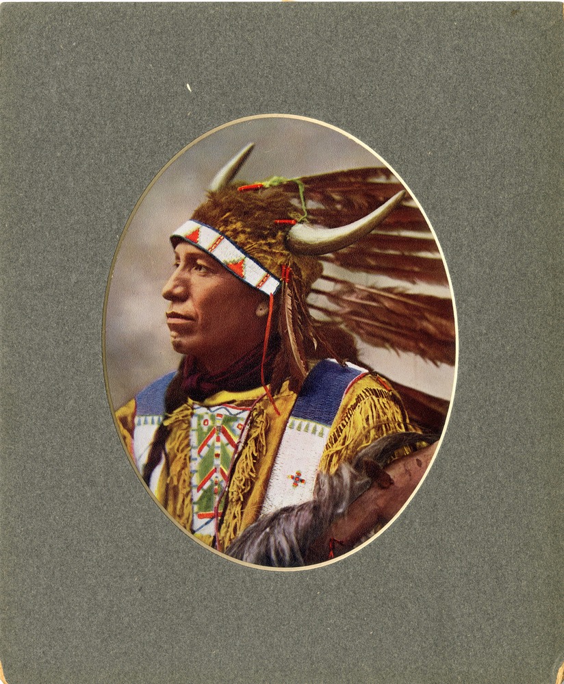 A color, offset lithograph print with grey mat; depicts a bust view of Northern Cheyenne chief in full dress