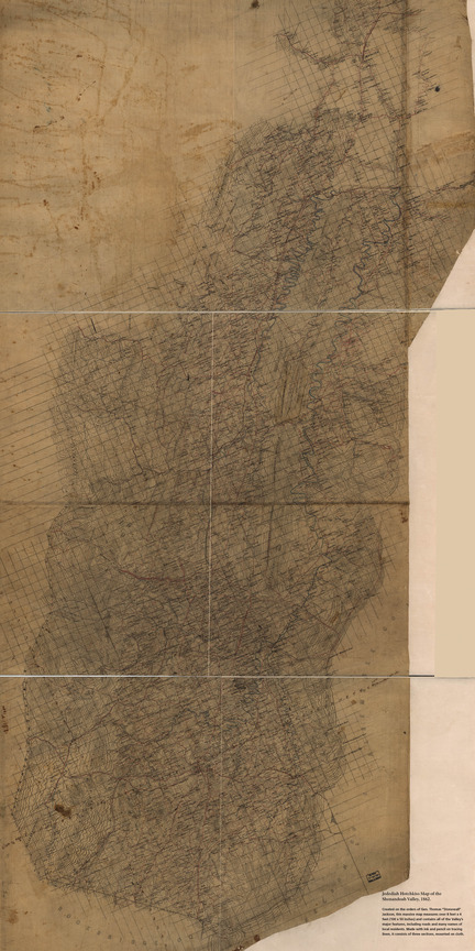 An eight feet tall exhibit panel has an image of a yellowed linen map, hand-drawn in great detail.