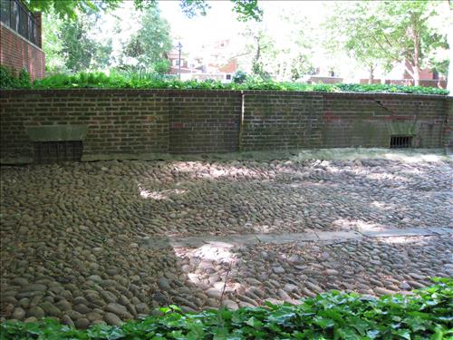 Cobblestone courtyard and adjacent wall of 18th century stable/carriagehouse in the Rose Barden in May 2009.