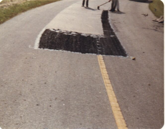 Petromat placed and being broomed smooth onto the emulsified asphalt