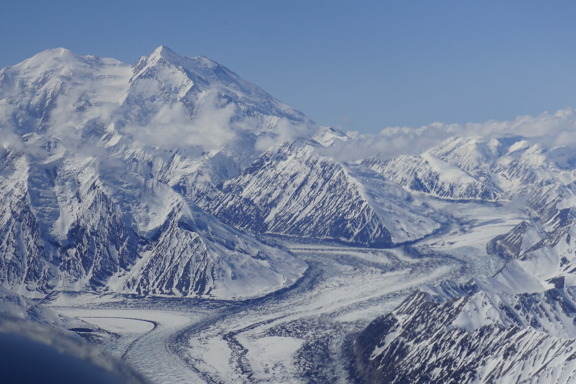 a glacier winding up through mountains toward a particularly enormous peak