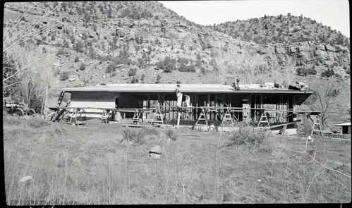 Construction, residence Building 15 with skeleton structure and workers on roof, Oak Creek.