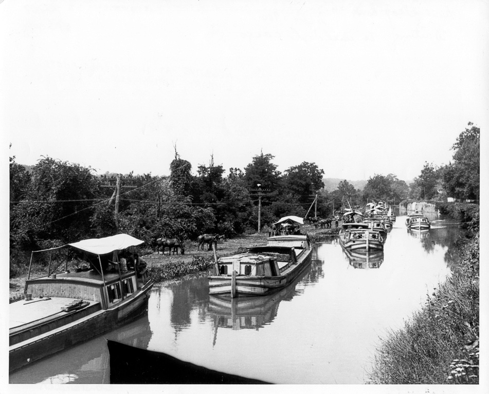 Historical photo of multiple canal boats docked in the canal
