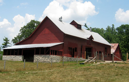 Large red barn surrounded by a fence