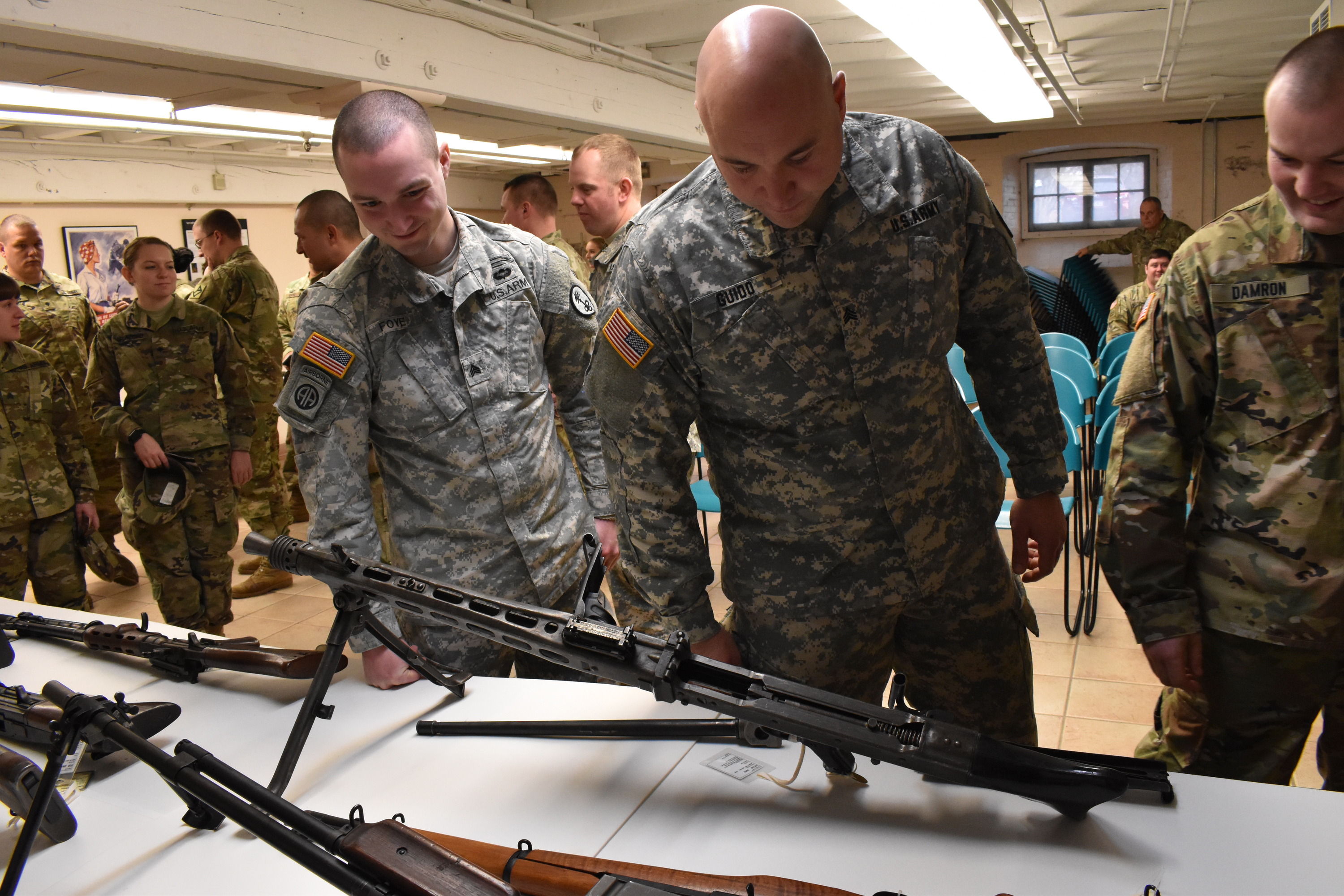 Uniformed soldiers view historic rifles