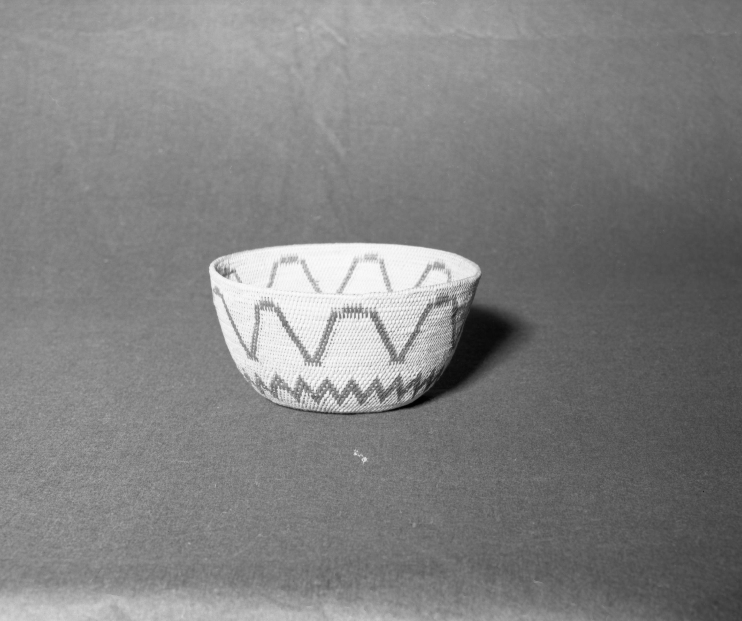 Mrs. Donald Segerstrom Collection. Object: Miwok Basket. Dimensions: 8 x 4". Materials: bracken fern root, split shoot. Technology: single rod, fag ends trimmed on work face, moving ends trimmed on interior, overstitched rim, clockspring start filled in by coiling on interior hole, two bands of design. Photographed by Michael Dixon, January 1983. Catalogued by Craig Bates and Barbara Beroza. Yosemite Collections, National Park Service.