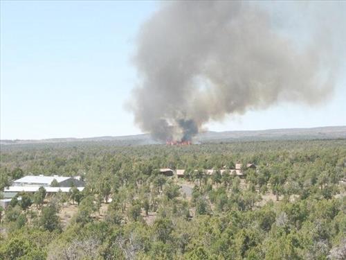Full fire with black smoke advancing on buildings on the first day of Long Mesa Fire, Mesa Verde National Park, July 29, 2002