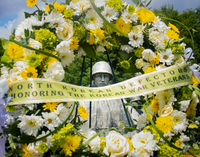 A statue of a soldier at the Korean War Veterans Memorial peeks its head through a wreath of yellow flowers for North Korean Defectors. 