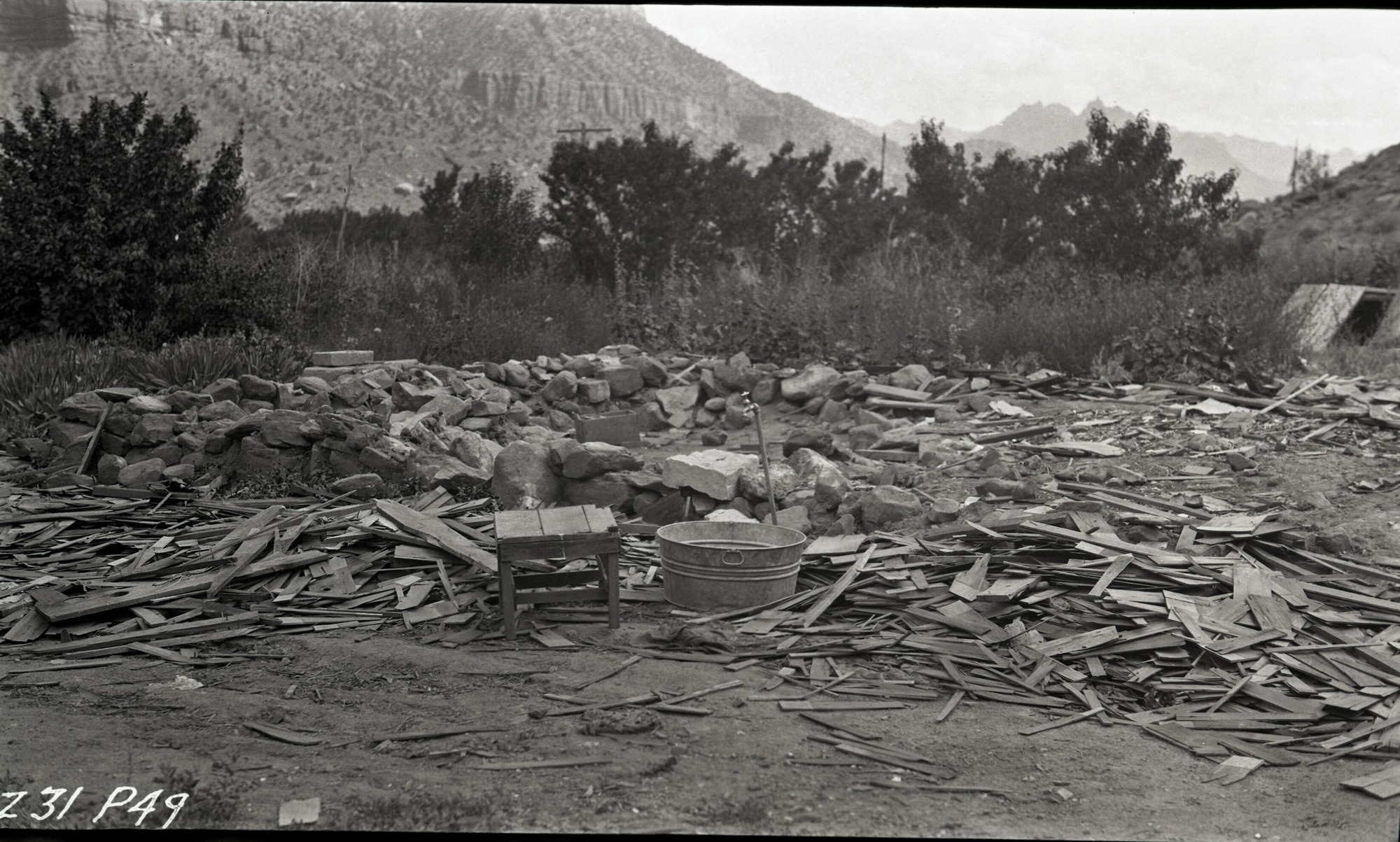 Unsightly conditions such as these occurred along the highway after original owners moved away. Small table, washtub and water spigot are visible among buildings debris.