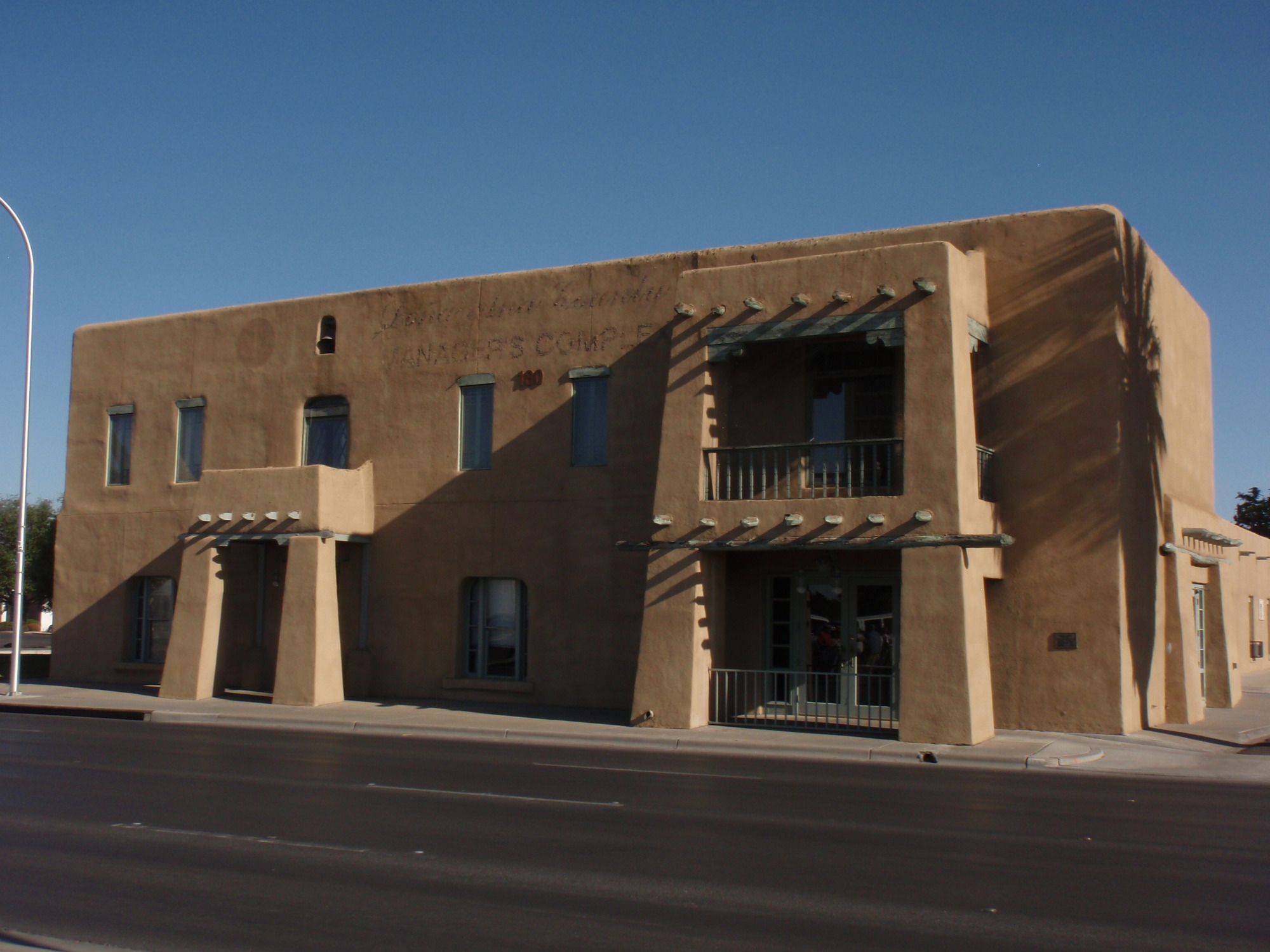 A tan building beside a road.